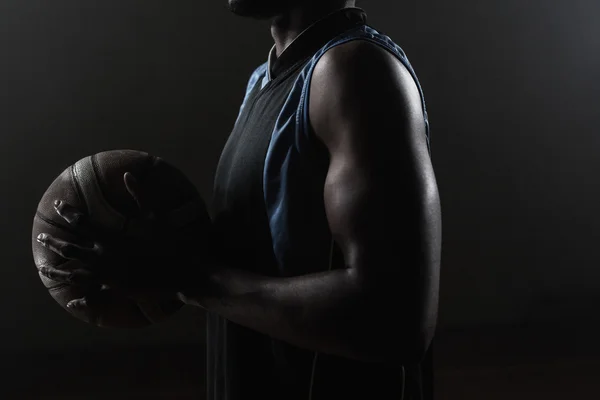 Zoom sur un côté d'un joueur de basket tenant un ballon de basket — Photo