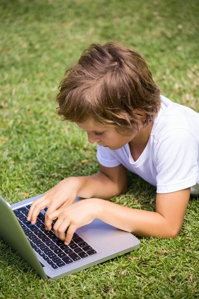 Child lying using a laptop Royalty Free Stock Images