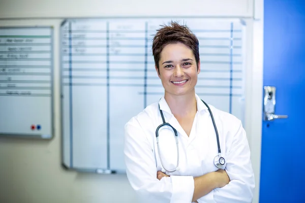 Mujer veterinaria sonriendo y posando con los brazos cruzados —  Fotos de Stock