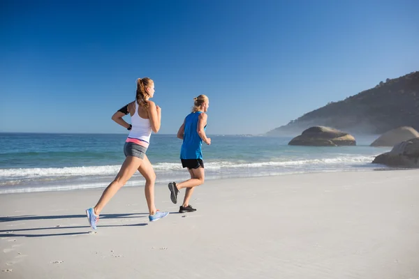 Freunde joggen am Strand — Stockfoto