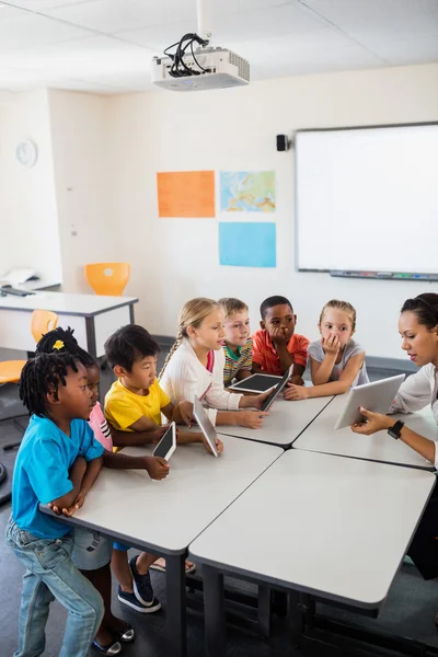 Leerlingen luisteren van de leraar met behulp van tablet pc — Stockfoto