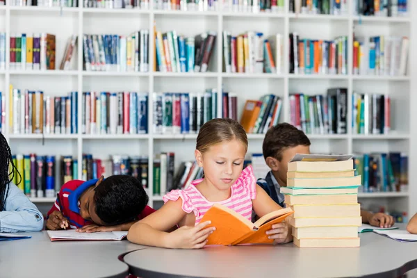 Ein kleines Mädchen liest Bücher — Stockfoto