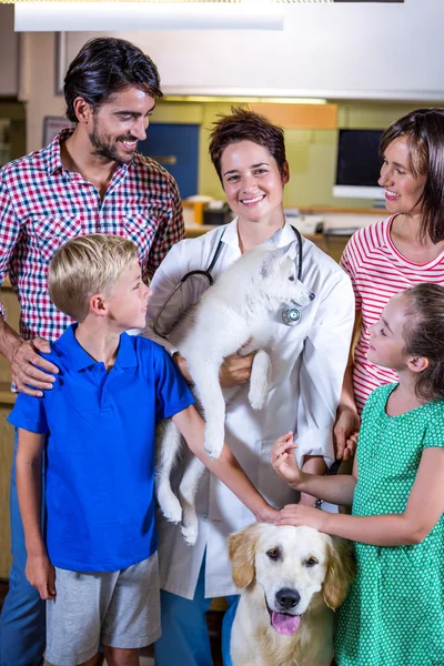 Donna veterinario sorridente e in possesso di un cucciolo carino — Foto Stock