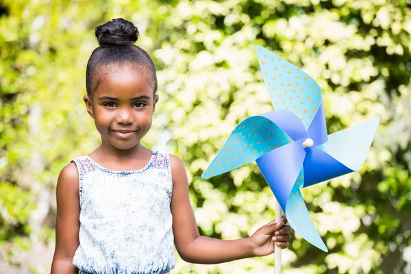 Маленькая девочка держит вертушку в парке — стоковое фото