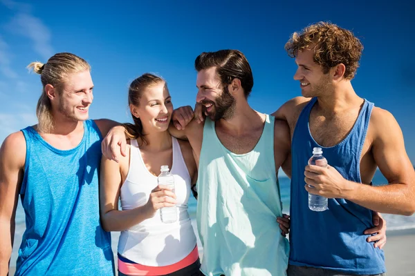 Vänner kramas på stranden — Stockfoto