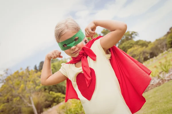 Portrait of young girl with superhero dress showing her muscles — Stock Photo, Image