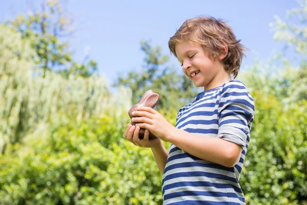 Retrato de niño lindo sosteniendo un conejo de chocolate —  Fotos de Stock