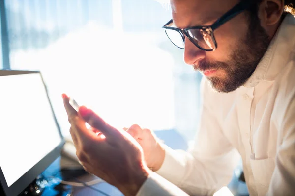 Affärsman arbetar och ser hans telefon — Stockfoto