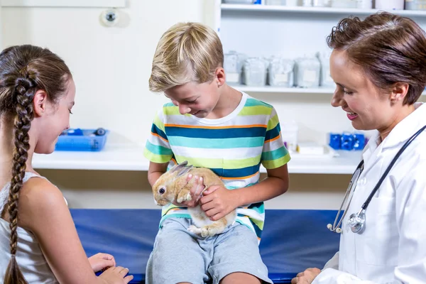 Kleine jongen die houden van een konijn omgeven door vrouw — Stockfoto