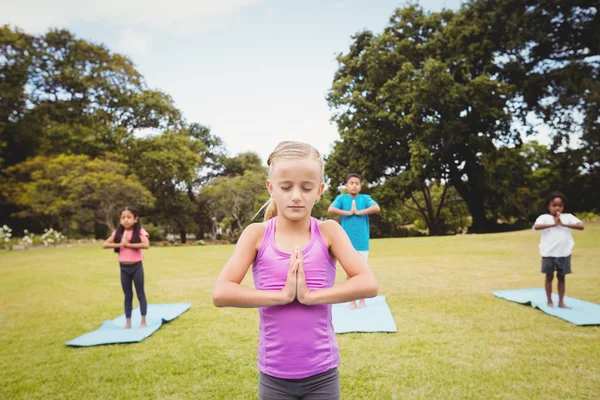 Gros plan sur une jeune fille faisant du yoga avec d'autres enfants — Photo