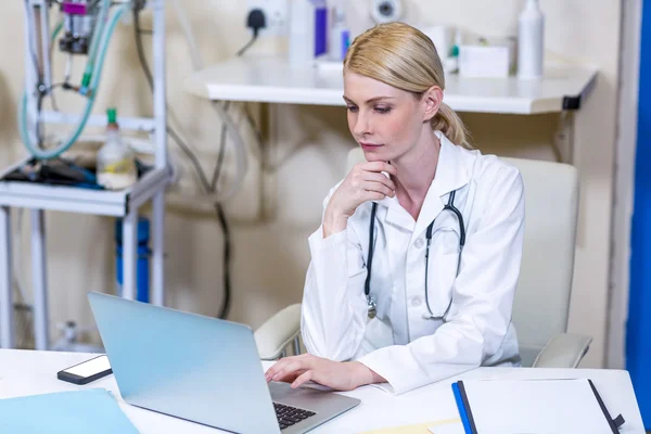 Una mujer veterinaria trabajando con su portátil — Foto de Stock