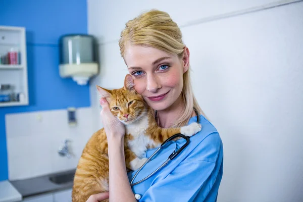 Uma mulher veterinária posando e sorrindo com um gato — Fotografia de Stock