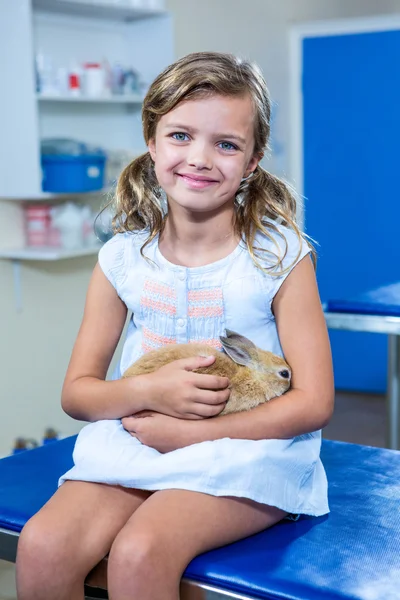 Ładna dziewczyna, trzymając jej królik i patrząc na kamery — Zdjęcie stockowe