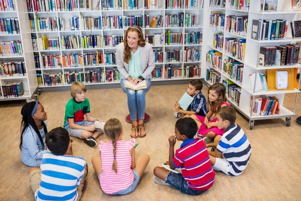 Teacher reading books to her students — Stock Photo, Image