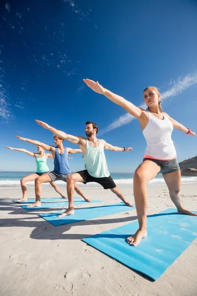 Människor som gör yoga på stranden — Stockfoto