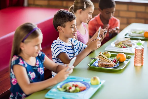 Children using technology during lunch — Stock Photo, Image