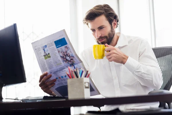 Businessman drinking coffee and reading newspapper — Stock Photo, Image