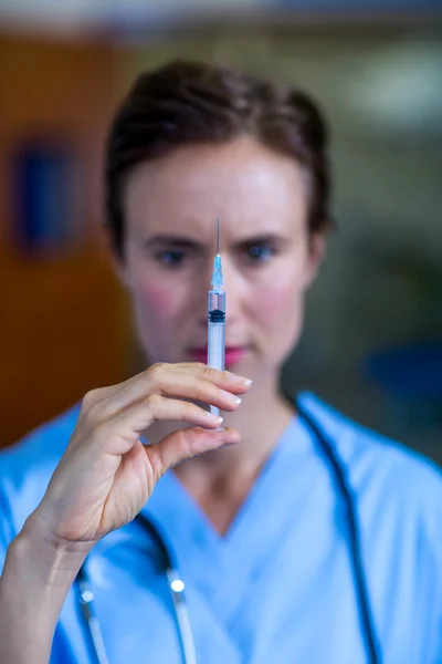 Una mujer veterinaria observando una jeringa — Foto de Stock