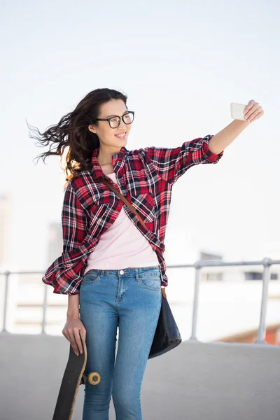 Hipster with skateboard taking pictures — Stock Photo, Image