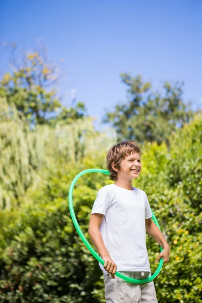 Niño sonriente jugando con un aro — Foto de Stock