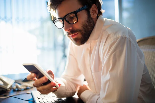 Zakenman werken en op zoek naar zijn telefoon — Stockfoto