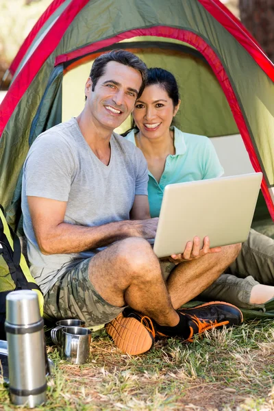 Пара улыбающихся и держащих ноутбук — стоковое фото