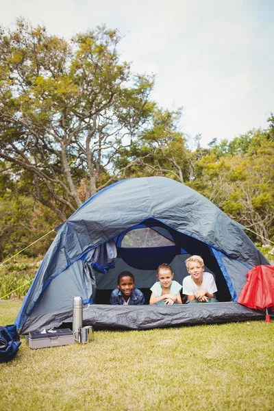 Children lying and smiling on a tent — Stock Photo, Image