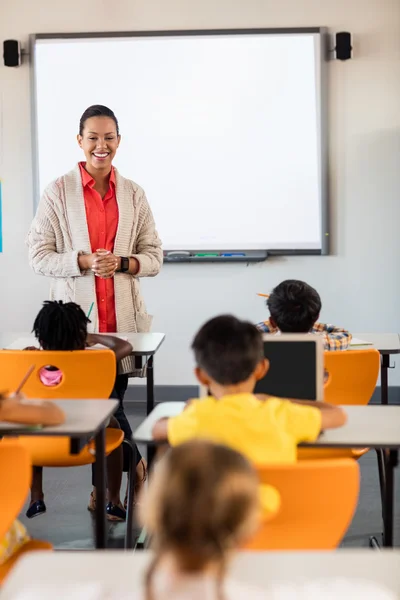 Teacher giving lesson to her students — Stock Photo, Image