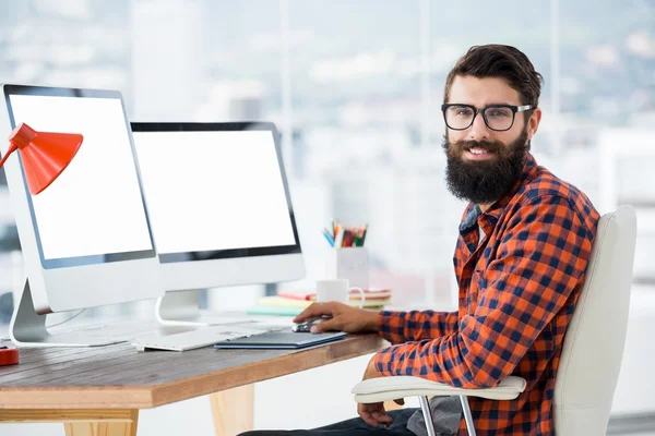 Hipster achter een computer zit — Stockfoto