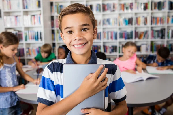 Junge schaut in Bibliothek auf Kamera mit Tablet-PC — Stockfoto