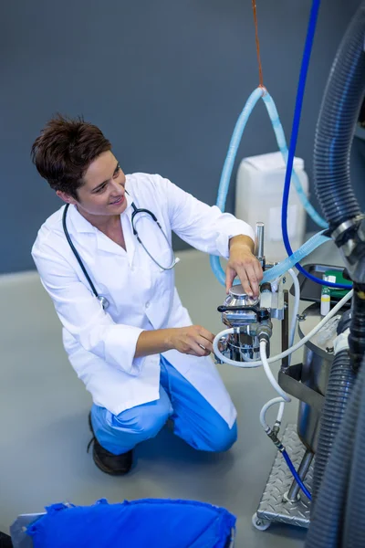 Mulher veterinária sorrindo e posando com uma máquina médica — Fotografia de Stock