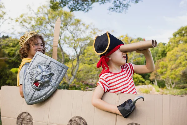 Portrait of children with fancy dress playing on cardboard boat — Stock Photo, Image