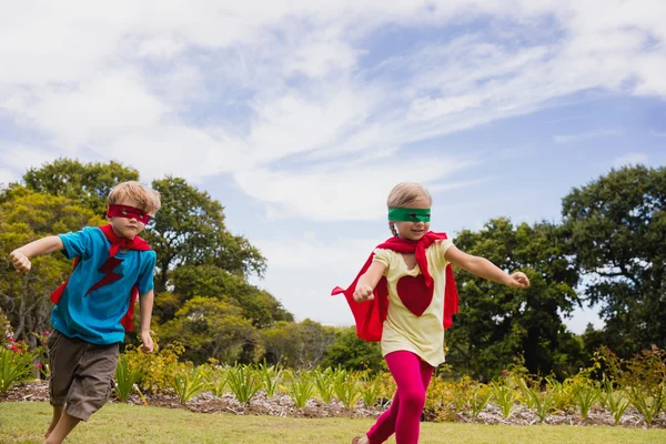 Barn med superhjälte klä kör och ler — Stockfoto