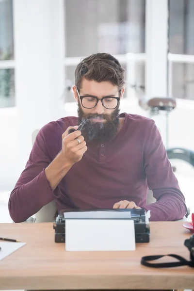 Hipster man using a typewriter and smoking the pipe — Stock Photo, Image