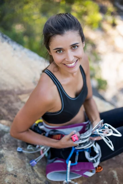 Donna sorridente e seduta con attrezzatura da arrampicata — Foto Stock
