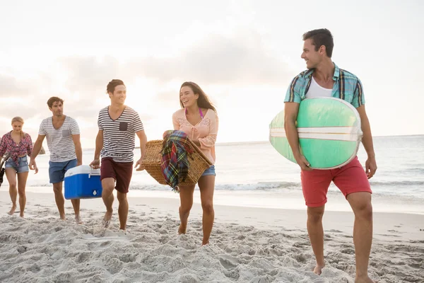 Amigos llevando una tabla de surf y una cesta —  Fotos de Stock