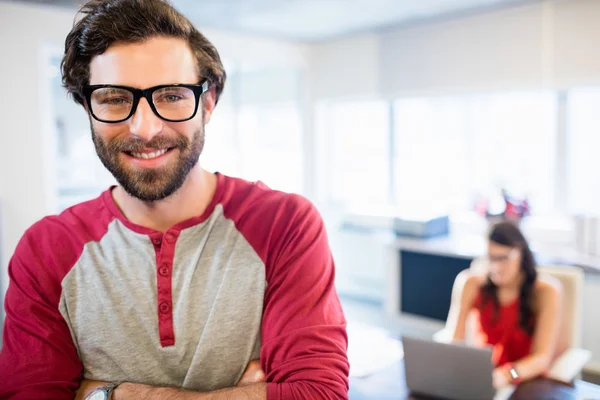 Un hombre de negocios sonriente con los brazos cruzados — Foto de Stock