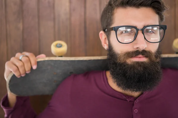 Hipster poserar med sin skateboard — Stockfoto