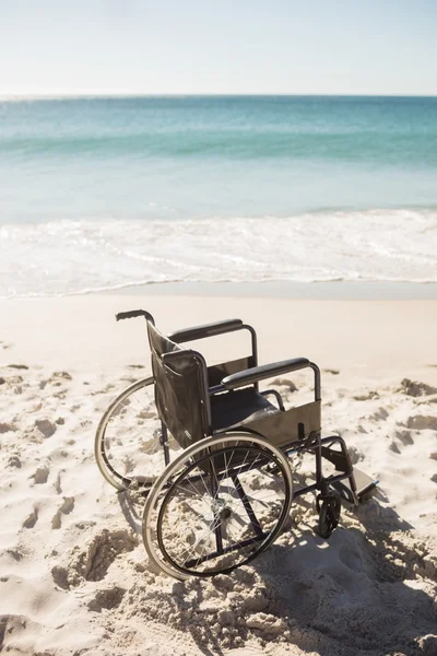 Silla de ruedas negra en la playa — Foto de Stock