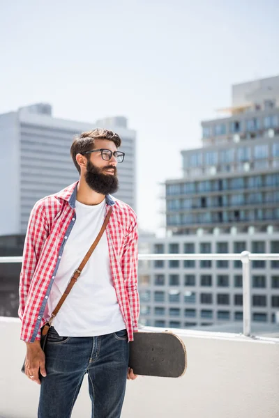 Hipster άνθρωπος που κρατά skateboard του — Φωτογραφία Αρχείου