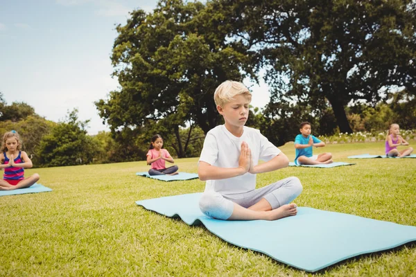 Ritratto di un ragazzo che fa yoga con altri bambini — Foto Stock