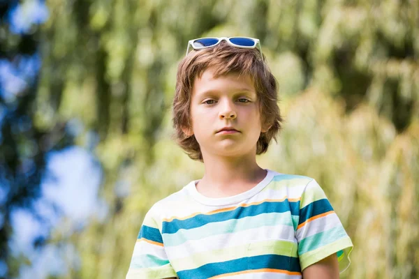 Um menino está usando óculos de sol — Fotografia de Stock