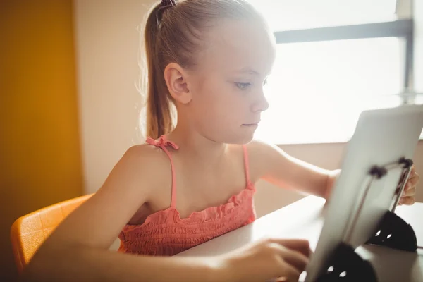 Dziewczyna siedzi przy użyciu cyfrowego tabletu — Zdjęcie stockowe