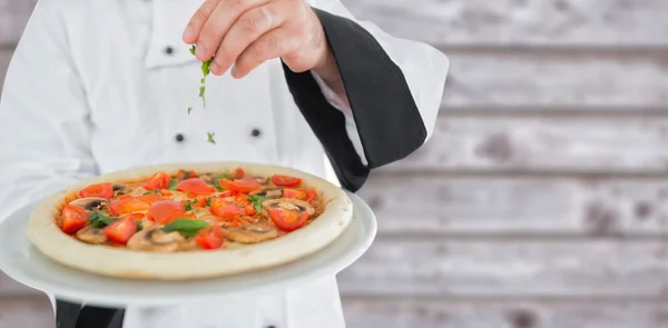 Hautnah auf einen Koch, der eine Pizza hält — Stockfoto