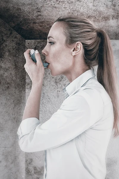 Όμορφη ξανθιά χρησιμοποιώντας μια συσκευή εισπνοών άσθμα — Φωτογραφία Αρχείου