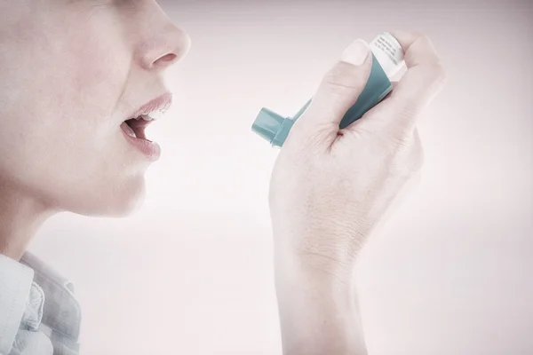 Close up of a woman using an asthma inhaler — Stock Photo, Image