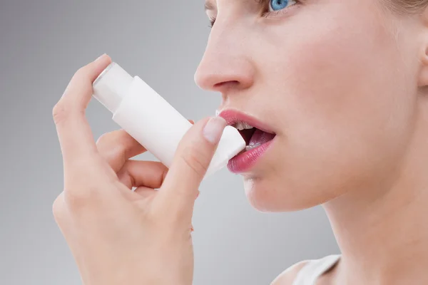 Mujer rubia tomando su inhalador — Foto de Stock