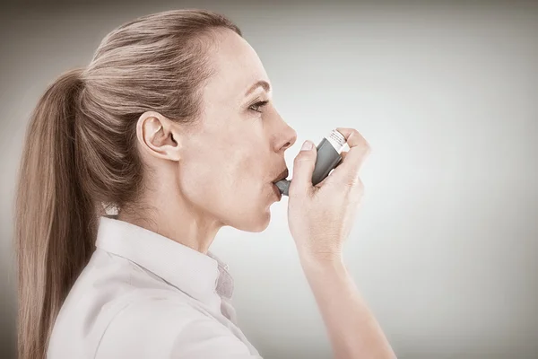 Mooie blonde met behulp van een astma-inhalator — Stockfoto