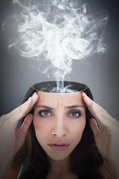 Composite image of pretty brunette with a headache — Stock Photo, Image