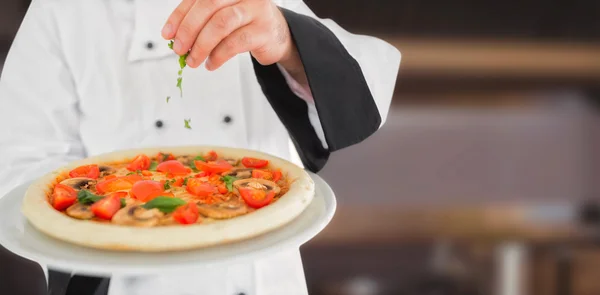 Fechar em cima de um chef segurando uma pizza — Fotografia de Stock